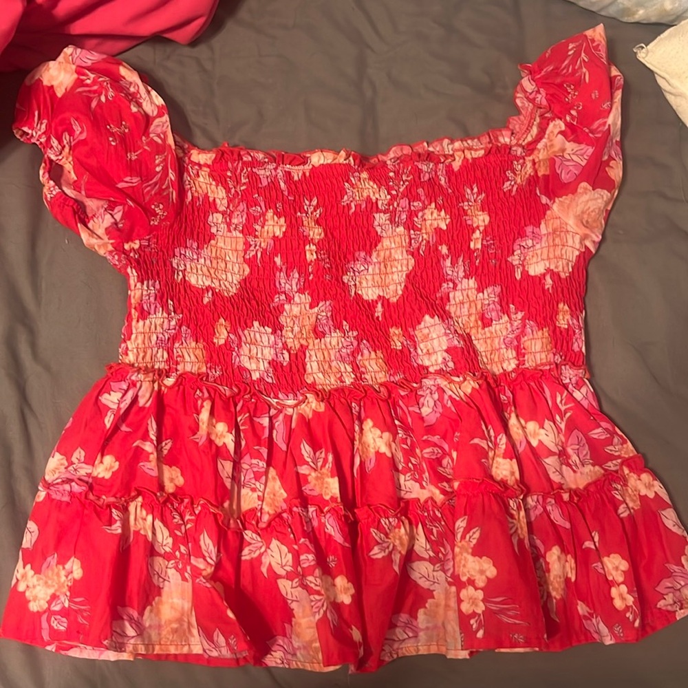 A red and flowered off the shoulder top. Form flattering and figure sculpting.
